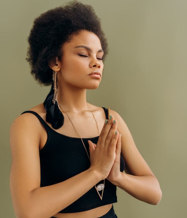 Woman in a calm yoga pose, surrounded by a serene atmosphere.